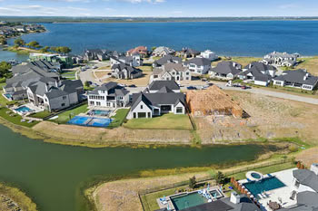 Aerial view of lakefront homes with backyard pools